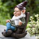 Nain de jardin souriant, assis sur un banc