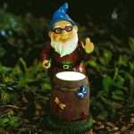 Nain de jardin souriant tenant un baril en bois