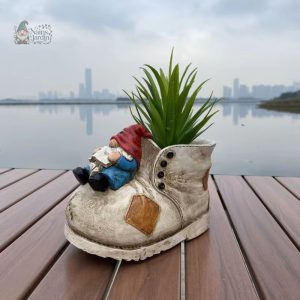 Nain de jardin souriant avec une botte décorative